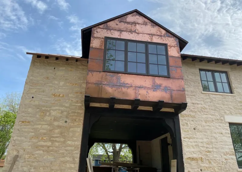 Copper metal panel facade on a stone building for Roof Repair in Brentwood